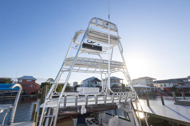 Slide: The Image of 2000 Island Hopper 30 boat with tall tower, docked near waterfront homes. - 27