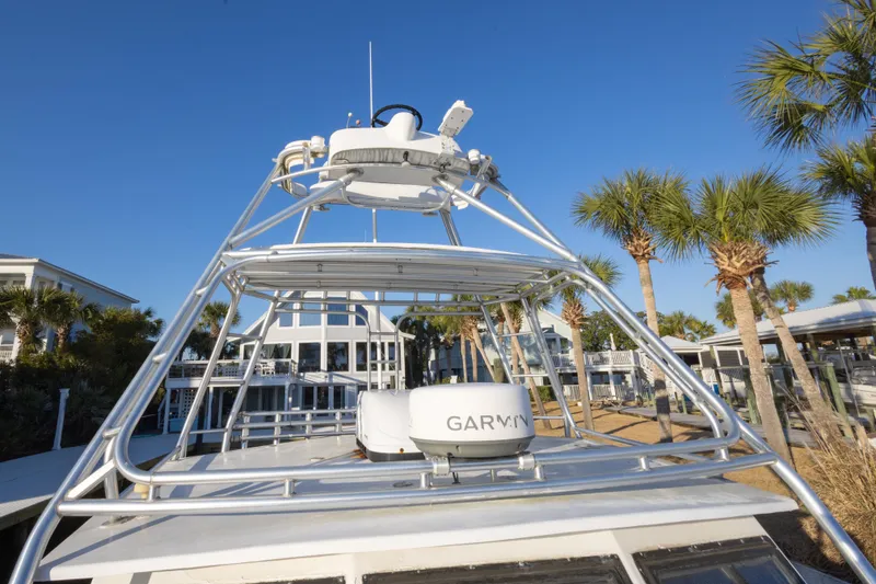 Slide: The Image of Island Hopper 30 boat, 2000 model, with radar equipment, docked near palm trees under clear blue sky. - 28