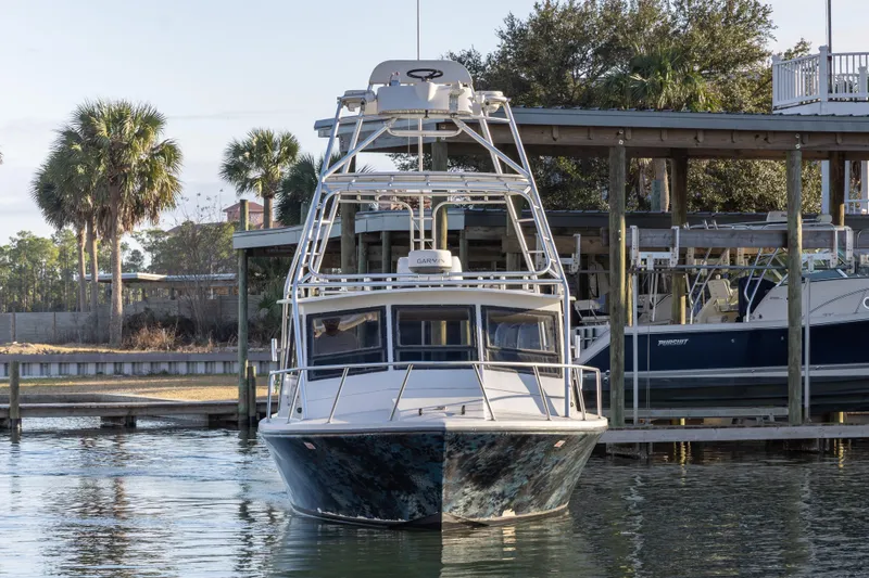 Slide: The Image of 2000 Island Hopper 30 boat docked near waterfront house with palm trees. - 3