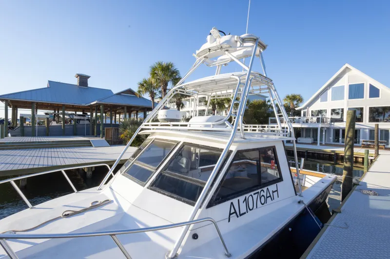 Slide: The Image of 2000 Island Hopper 30 boat docked near waterfront homes and palm trees. - 31