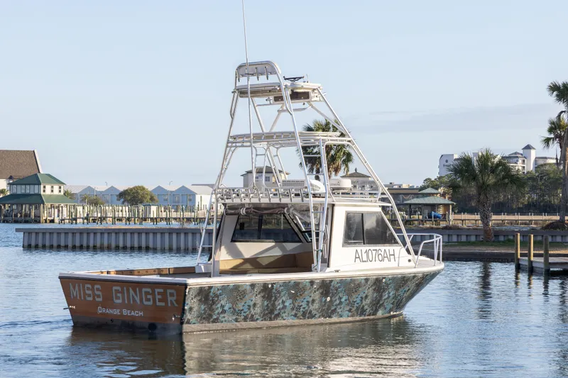 Slide: The Image of Island Hopper 30 boat, 2000 model, docked in a marina with modern buildings. - 7