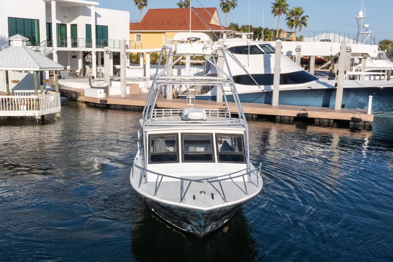 Slide: The Image of 2000 Island Hopper 30 boat "Miss Ginger" in Orange Beach marina, featuring a tower and coastal backdrop. - 8