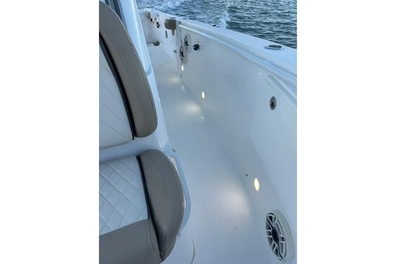 Slide: The Image of 2020 Everglades 335 Center Console boat interior with cushioned seating and deck lighting. - 15