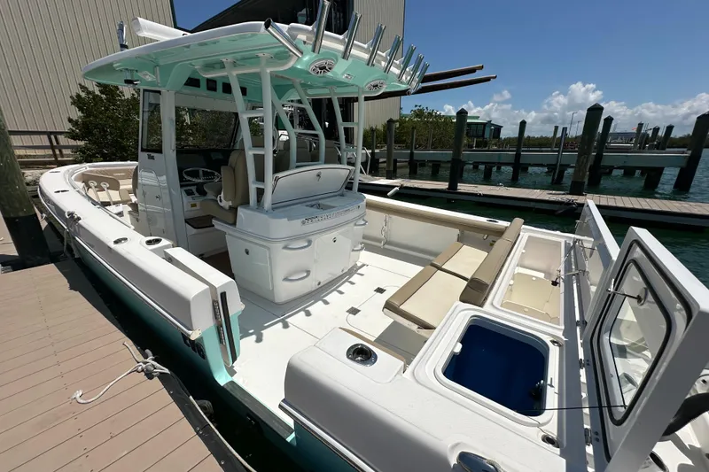 Slide: The Image of 2020 Everglades 335 Center Console boat docked, featuring spacious seating and modern amenities. - 22