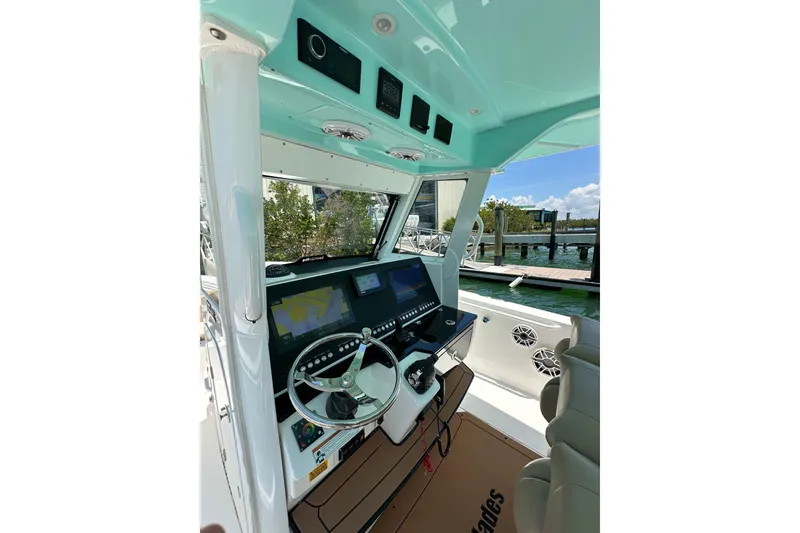 Slide: The Image of 2020 Everglades 335 Center Console boat interior with advanced navigation system and steering wheel. - 23