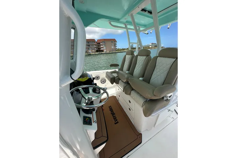 Slide: The Image of 2020 Everglades 335 Center Console boat interior with luxurious seating and steering wheel. - 24