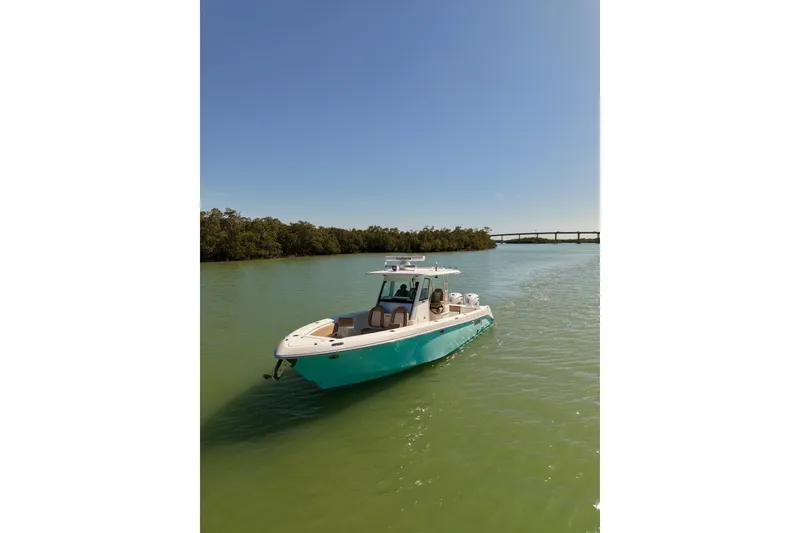 Slide: The Image of 2020 Everglades 335 Center Console boat on calm water under clear blue sky. - 4