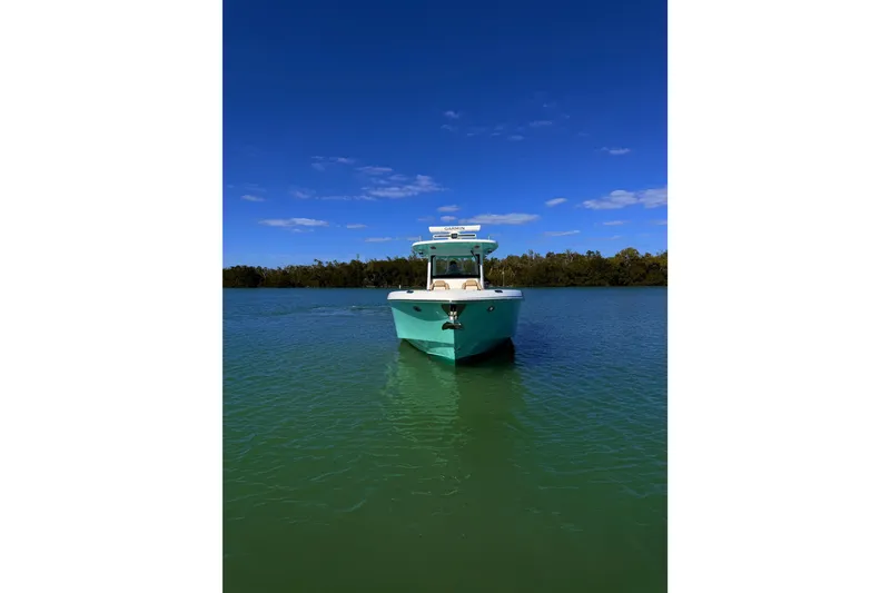 Slide: The Image of 2020 Everglades 335 Center Console boat on calm water under clear blue sky. - 5