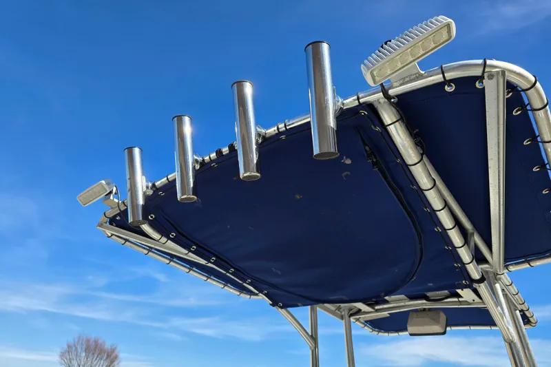 Slide: The Image of Triton 240 LTS 2004 boat canopy with rod holders against a clear blue sky. - 10