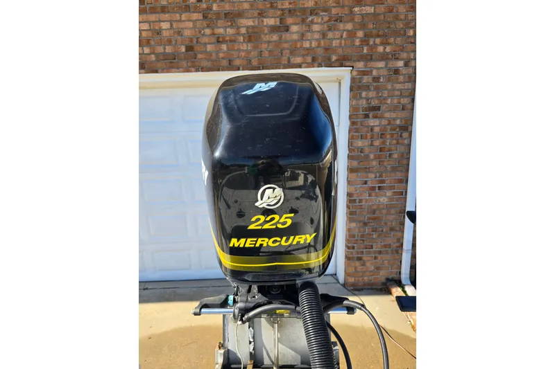 Slide: The Image of Mercury 225 outboard motor on 2004 Triton 240 LTS boat, brick wall background. - 11