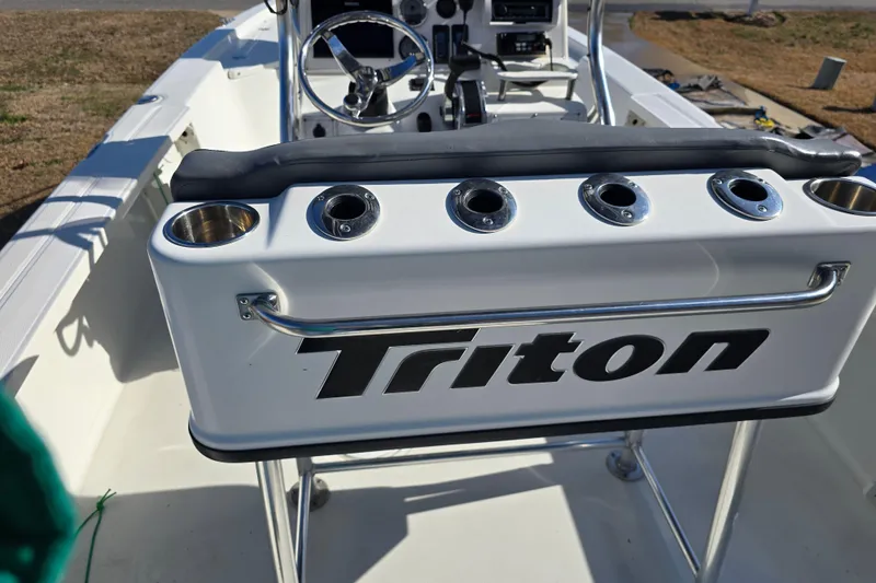 Slide: The Image of 2004 Triton 240 LTS boat interior with rod holders and steering console. - 15
