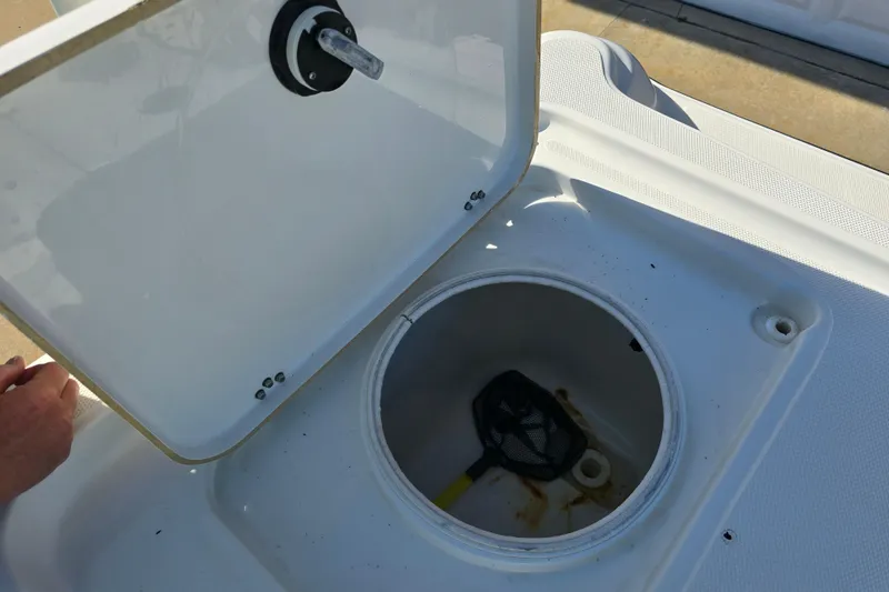 Slide: The Image of Open hatch on 2004 Triton 240 LTS boat showing storage compartment with net. - 24