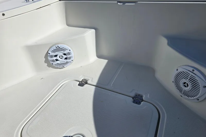 Slide: The Image of 2004 Triton 240 LTS boat interior with Kenwood speakers and storage compartment. - 26