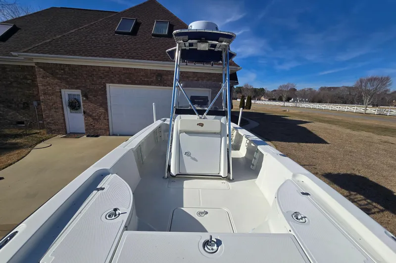 Slide: The Image of 2004 Triton 240 LTS boat parked in driveway, clear blue sky background. - 27