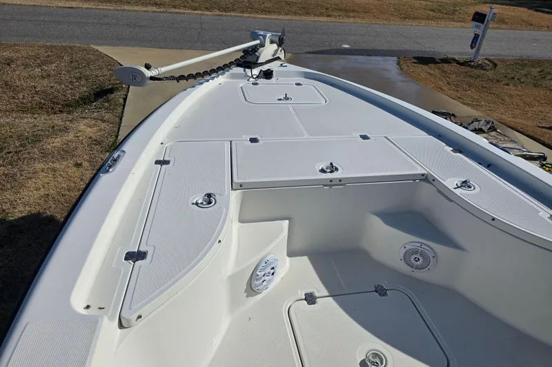 Slide: The Image of 2004 Triton 240 LTS boat deck with storage compartments and trolling motor. - 28