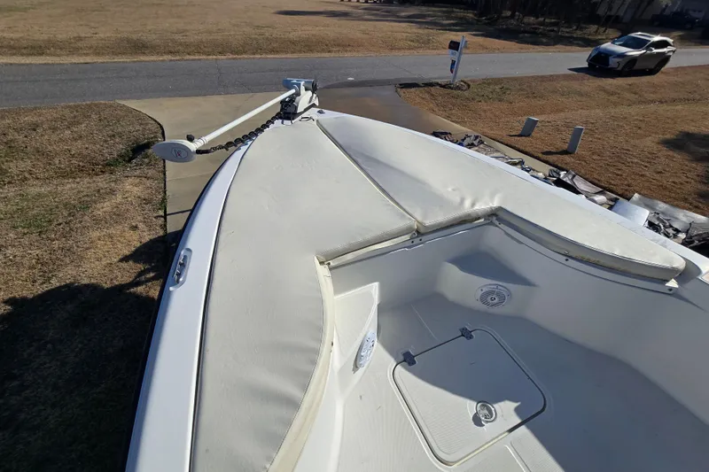 Slide: The Image of 2004 Triton 240 LTS boat bow with seating and anchor, parked on a driveway. - 29