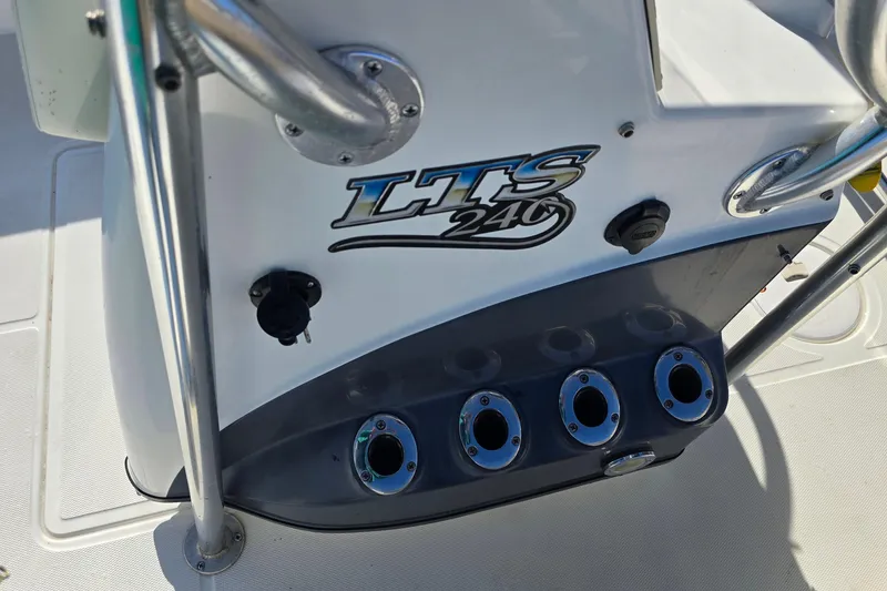 Slide: The Image of 2004 Triton 240 LTS boat console with rod holders and logo detail. - 32