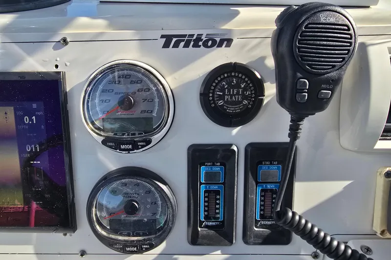 Slide: The Image of Dashboard of a 2004 Triton 240 LTS boat with gauges and radio controls. - 33