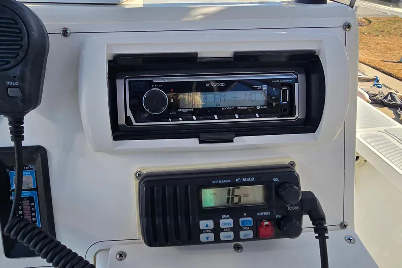 Slide: The Image of 2004 Triton 240 LTS boat dashboard with Kenwood stereo and VHF marine radio. - 34