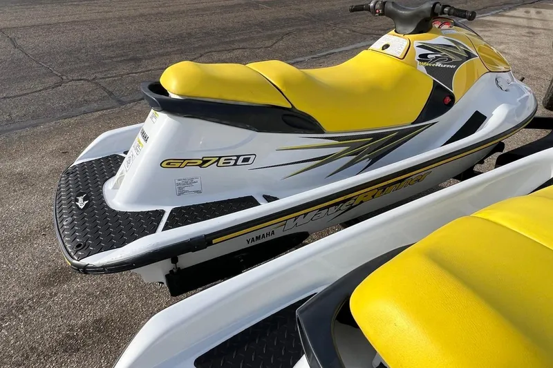 Slide: The Image of 1998 Yamaha GP760 WaveRunner with yellow seat and sleek design on pavement. - 6