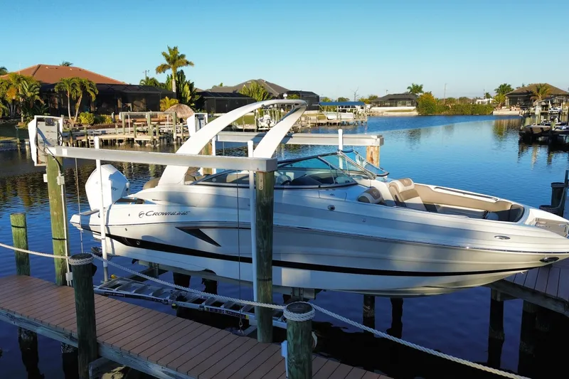 Slide: The Image of 2020 Crownline Eclipse E255 XS boat docked on a serene waterfront. - 0