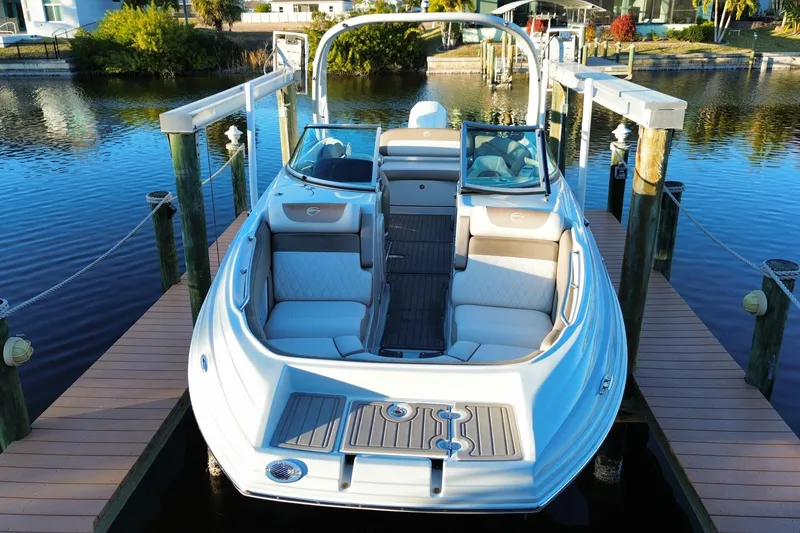 Slide: The Image of 2020 Crownline Eclipse E255 XS boat docked on calm water. - 2