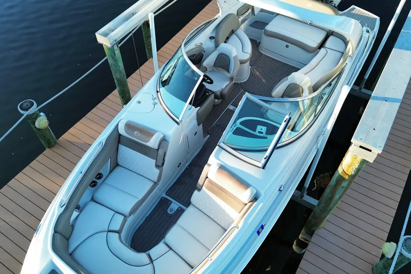 Slide: The Image of 2020 Crownline Eclipse E255 XS boat docked, featuring spacious seating and sleek design. - 3