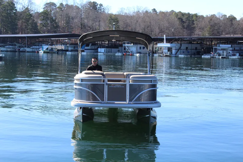 Slide: The Image of 2025 Tracker PB 20 DLX pontoon boat on calm water. - 4