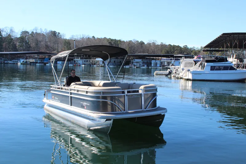 Slide: The Image of 2025 Tracker PB 20 DLX pontoon boat on calm water. - 8