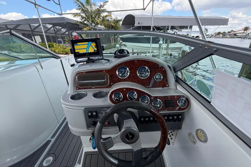 Slide: The Image of 2004 Formula 260 Bowrider dashboard with navigation system and gauges, docked by the water. - 11