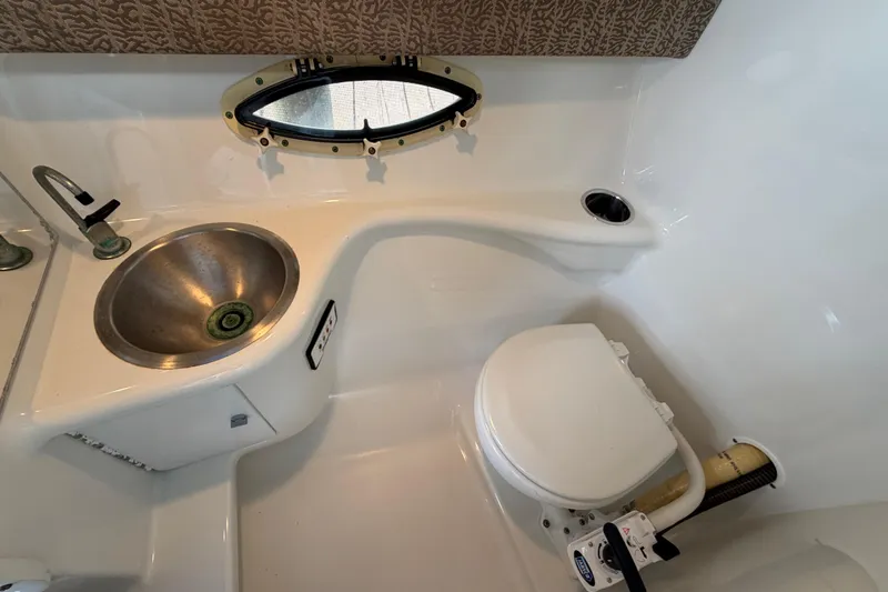 Slide: The Image of 2004 Formula 260 Bowrider bathroom with sink, toilet, and porthole window. - 25