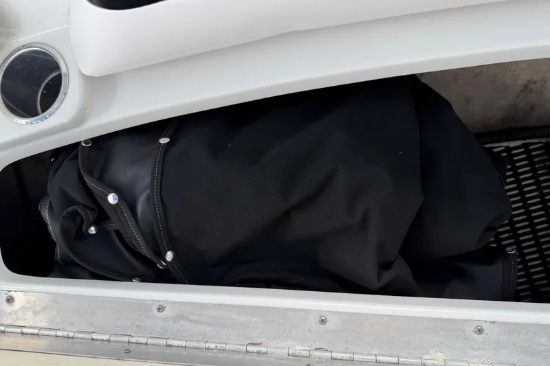 Slide: The Image of Storage compartment in a 2004 Formula 260 Bowrider boat with black cover inside. - 27