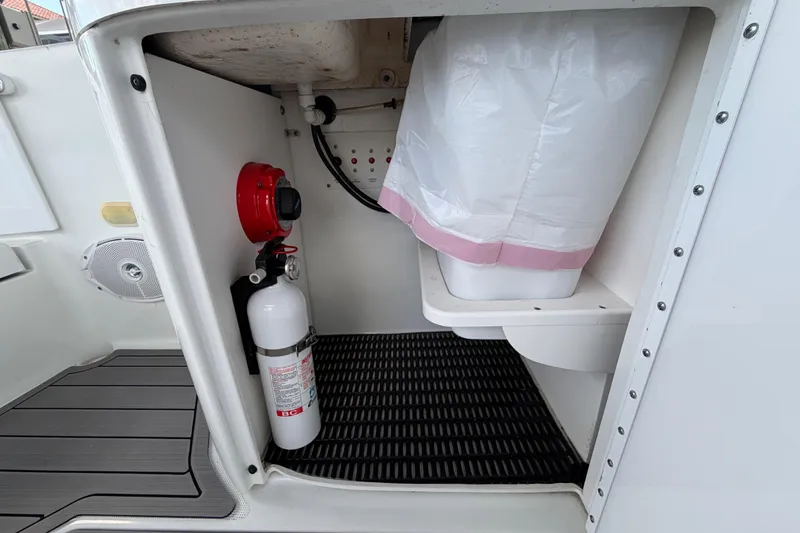 Slide: The Image of Storage compartment in a 2004 Formula 260 Bowrider with fire extinguisher and trash bin. - 31
