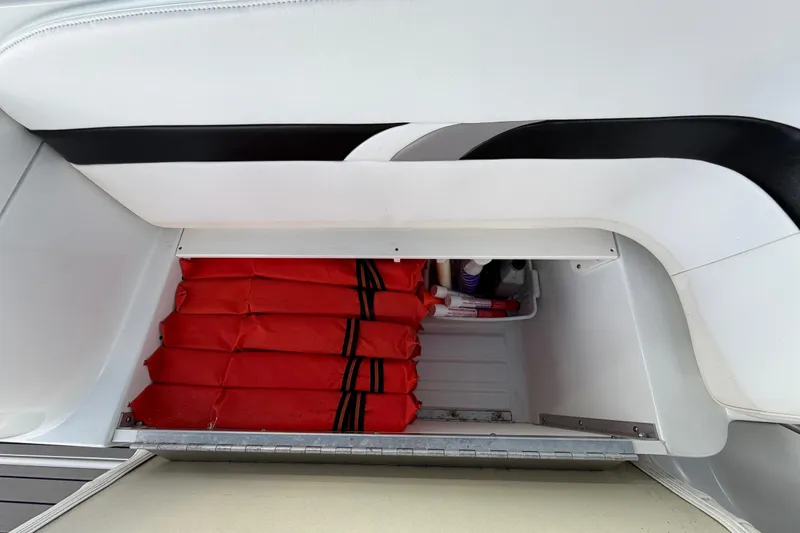 Slide: The Image of Storage compartment in a 2004 Formula 260 Bowrider with red life jackets. - 32