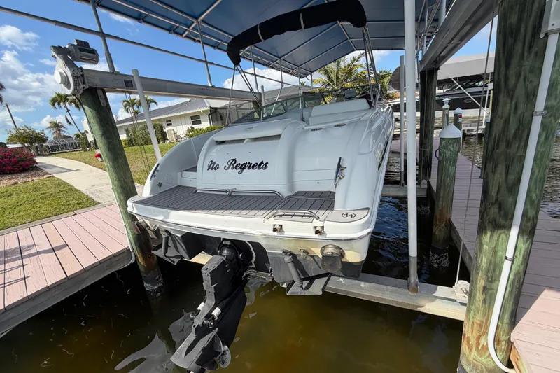 Slide: The Image of 2004 Formula 260 Bowrider boat named "No Regrets" docked under a canopy. - 5
