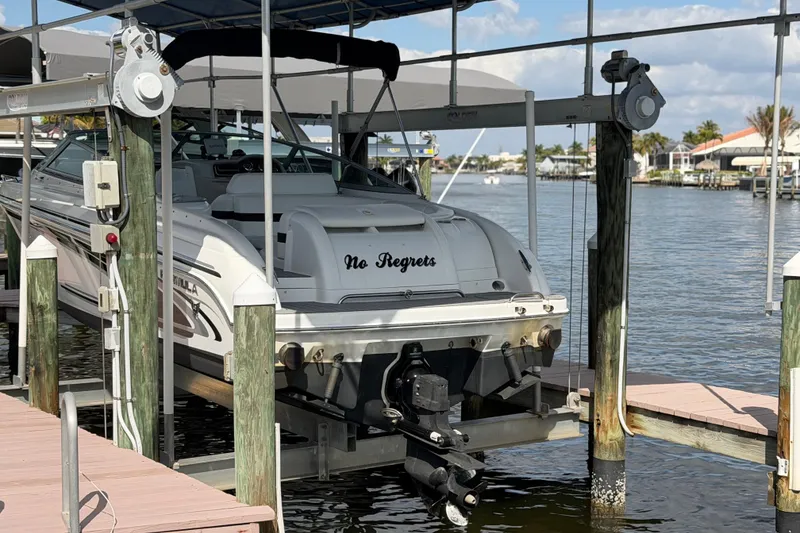 Slide: The Image of 2004 Formula 260 Bowrider boat named "No Regrets" docked on a lift by the water. - 8