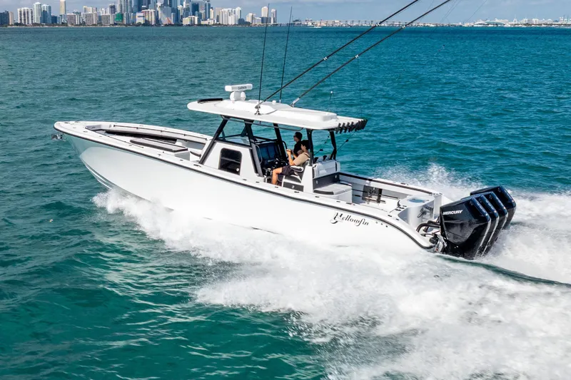 Slide: The Image of 2024 Yellowfin 39 Offshore boat cruising on ocean with city skyline in background. - 13