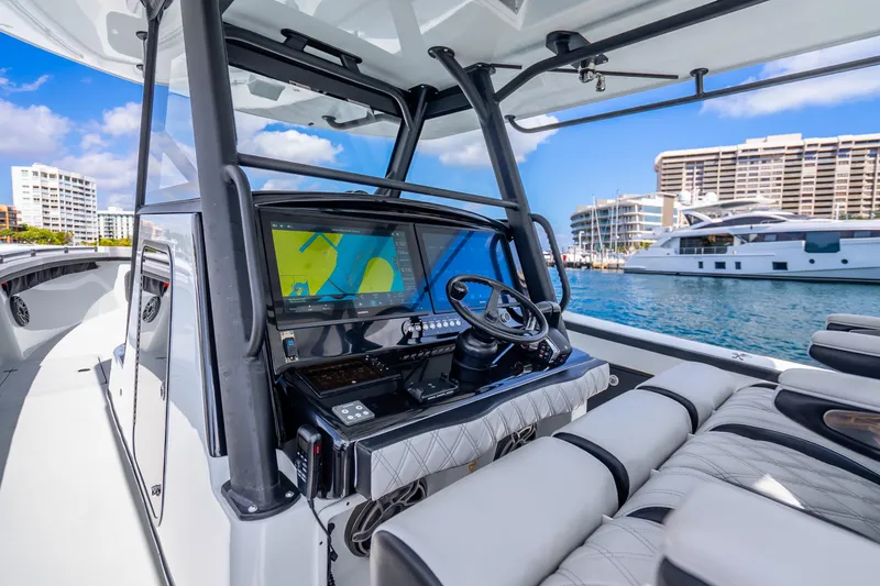 Slide: The Image of 2024 Yellowfin 39 Offshore boat interior with advanced navigation system, docked in a marina. - 15