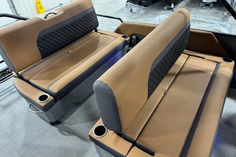 Slide: The Image of 2026 Sylvan L-5 boat interior with tan and black seating, featuring cup holders. - 11