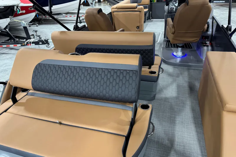 Slide: The Image of 2026 Sylvan L-5 boat interior with tan and gray seating, cup holders, and modern design. - 12