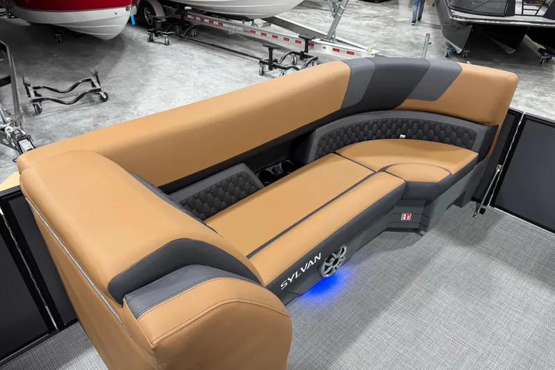 Slide: The Image of Luxurious 2026 Sylvan L-5 boat seating with tan and gray upholstery in showroom. - 13