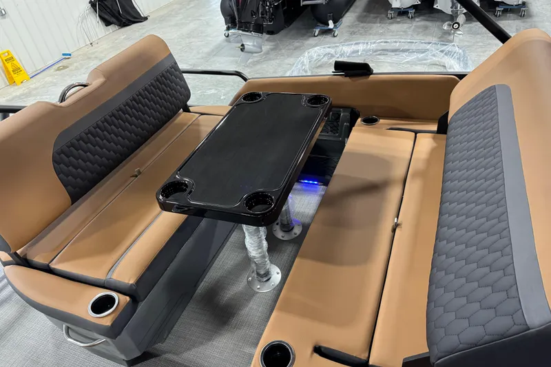 Slide: The Image of Luxurious interior of 2026 Sylvan L-5 boat with tan seating and black table. - 16