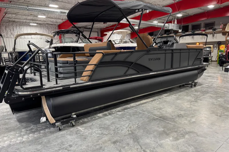 Slide: The Image of 2026 Sylvan L-5 pontoon boat in showroom, featuring sleek black design and comfortable seating. - 4