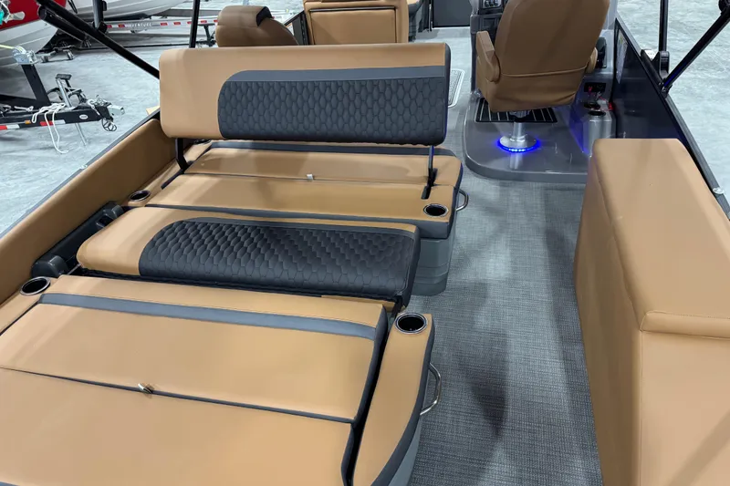 Slide: The Image of 2026 Sylvan L-5 boat interior with tan and black seating, cup holders, and modern design. - 9