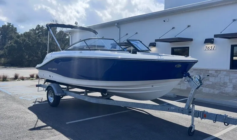 Slide: The Image of 2026 Bayliner V20 boat on trailer in front of building. - 8