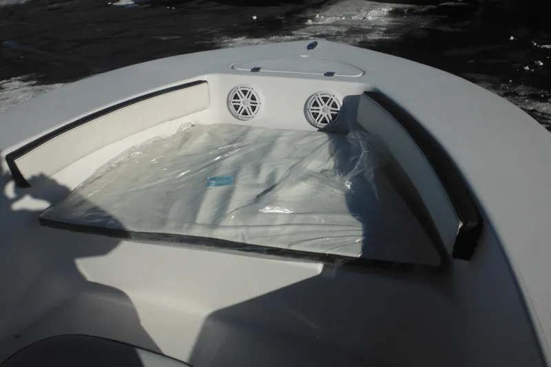 Slide: The Image of 2026 Tidewater 180 CC Adventure boat interior with cushioned seating and speakers. - 16