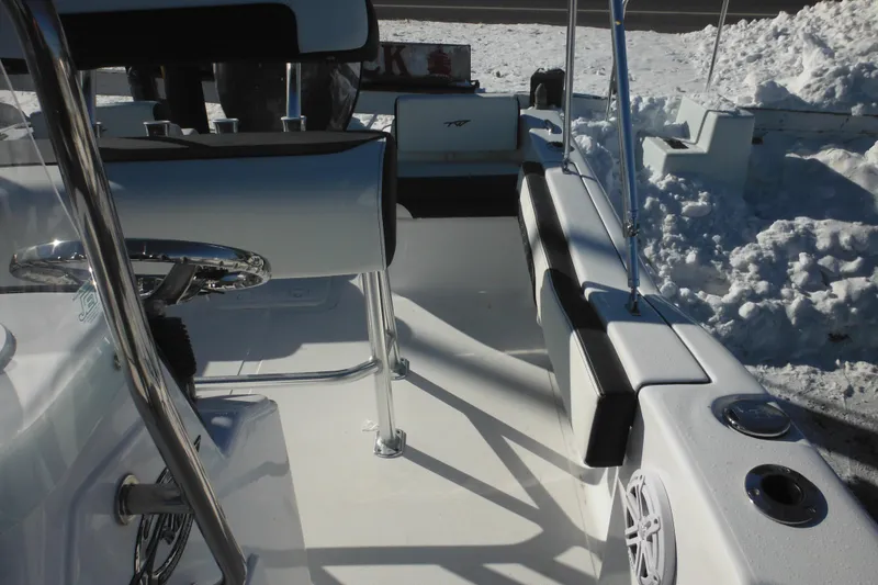 Slide: The Image of 2026 Tidewater 180 CC Adventure boat interior with seating and steering wheel, surrounded by snow. - 22