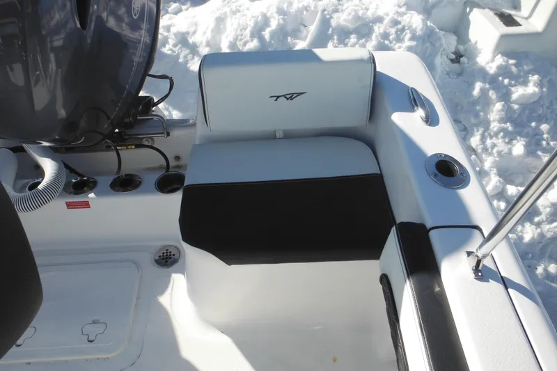 Slide: The Image of 2026 Tidewater 180 CC Adventure boat interior with seating and motor, surrounded by snow. - 24