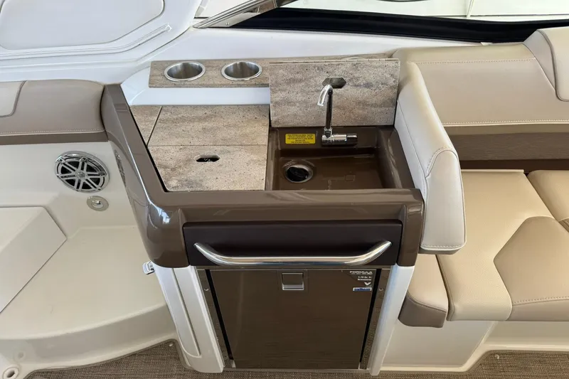 Slide: The Image of 2018 Formula 310 Bowrider boat interior with sink, countertop, and seating area. - 15
