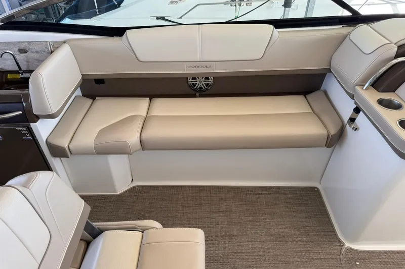 Slide: The Image of 2018 Formula 310 Bowrider interior with beige seating and cup holders. - 18